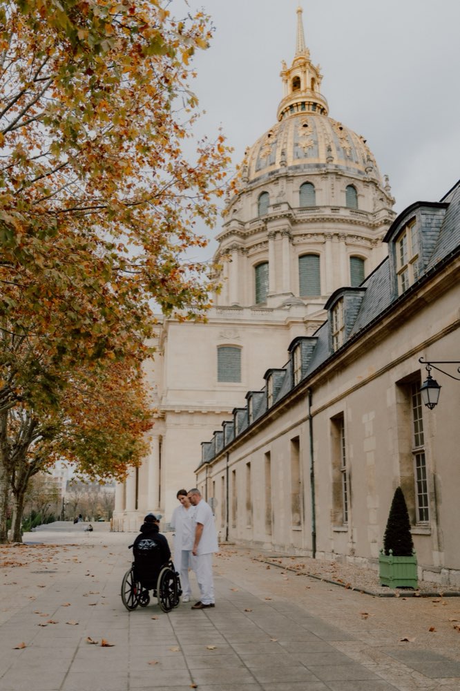 Résident accompagné en promenade devant le dôme doré des Invalides