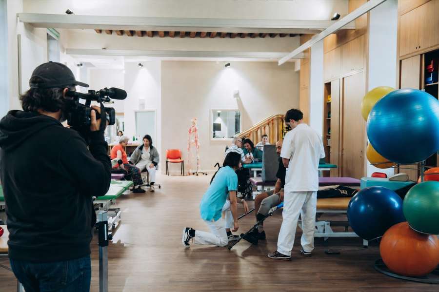 Une équipe de tournage filme une séance de rééducation dans la salle de réhabilitation de l'INI