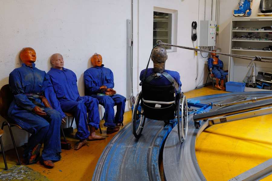Banc d'essai du CERAH : mannequins de test et fauteuil roulant sur une piste d'essai de choc